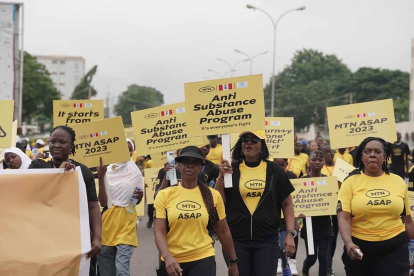 MTN ASAP rally with participants holding yellow signs